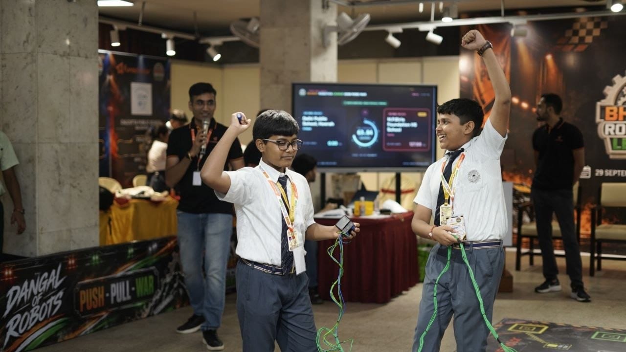 Two students celebrating with their fists in the air after a match